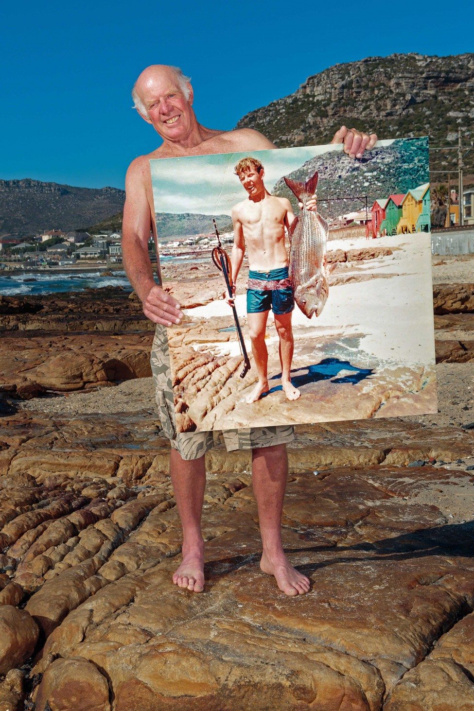 In December 1968, Geoff Fridjhon posed for a photo holding a large white musselcracker Sparodon durbanensis he had caught while spearfishing off Dalebrook beach. A fish of this size would have been close to 30 years old. Forty-six years later Fridgeon stands in the exact same spot holding an enlargement of the photo. Today the species has all but disappeared from False Bay. A white musselcracker can take more than five years to reach sexual maturity, which makes the species highly susceptible to overfishing.